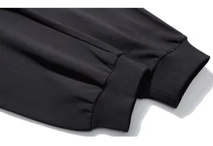 Macro shot of black ribbed cuffs and dense cotton fabric on oversized sports pants