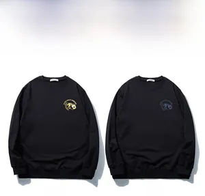 Detail of panda badge prints in gold and blue on black oversized men's sweatshirts