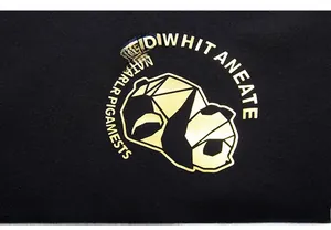 Close-up of golden geometric panda print on a high-quality black cotton hoodie fabric