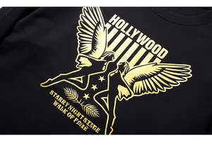 Detail of golden Hollywood print on black oversized cotton sweatshirt with metallic finish