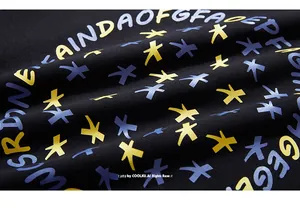 Détail macro de l'imprimé graphique coloré sur le tissu noir du sweat-shirt en coton