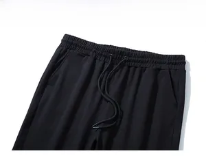 Detail of black sports trousers featuring elastic waist with drawstring and side pockets