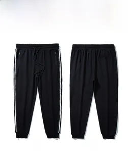 Front and back view of black sweatpants featuring side letter ribbon and drawstring waist