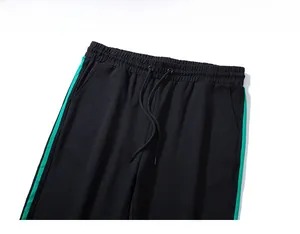Dettaglio della vita elastica con coulisse e strisce laterali verdi sui pantaloni sportivi