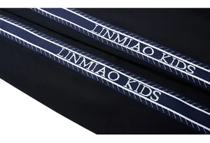 Detailed close-up of blue track pants with white LINMIAO KIDS side stripe branding