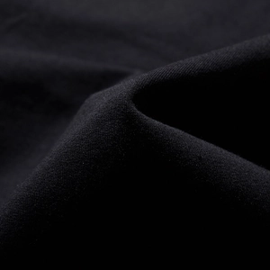 Detail of high-density black combed cotton fabric with soft texture on men's oversized hoodie