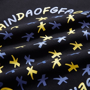 Détail d'un sweat-shirt noir oversize avec imprimé de lettres et motifs étoilés