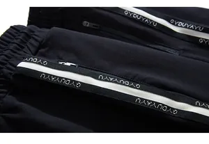Detail of black jogger pants featuring a zipper pocket and contrast branded tape