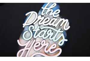 Detail of the Dream Starts Here colorful screen print on a black long-sleeve cotton T-shirt