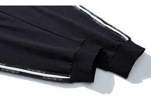 Detail of ribbed cuffs and contrast letter tape on black men's joggers pants