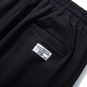 Close-up of black men's sports joggers with elastic waist and woven label detail