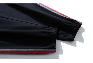 Detail of black sports joggers featuring elastic ribbed cuffs and side stripe webbing