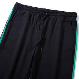 Pantaloni sportivi neri da uomo con elastico in vita e strisce laterali verde brillante