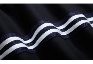 Gros plan détaillé du tissu en maille noire avec des bandes latérales bleues et blanches