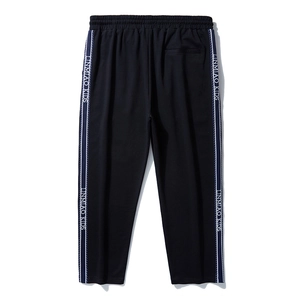Kids black sports joggers with elastic waist and side white stripe tape branding