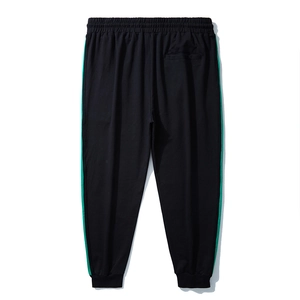 Pantaloni sportivi neri da uomo con strisce laterali verdi e polsini a costine