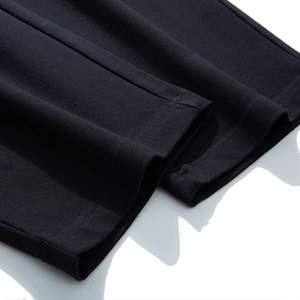 Close-up of black sports pants showing durable double-needle stitching and knit texture