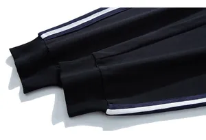 Détail des poignets côtelés et des bandes latérales sur un pantalon de sport noir