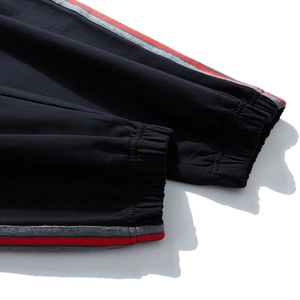 Men's loose jogger pants with elastic cuffs and signature striped side ribbon details