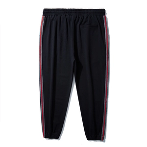 Men's loose black joggers with red and grey side stripes and elastic waist cuffs