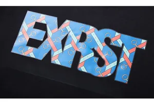 Close-up of vibrant colorful EXST letter prints on premium black knitted fabric detail