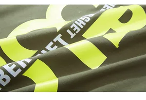 Close-up of military green knit fabric featuring neon yellow high-density graphic print