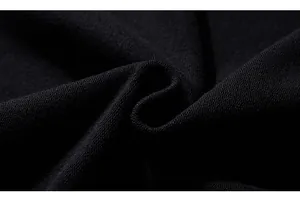 Close-up of thick black knitted fabric showing premium fiber density and sweater texture