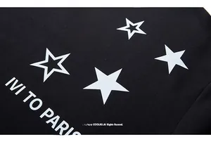Detail of street fashion black sweatshirt fabric featuring white star print and IVI TO PARIS text