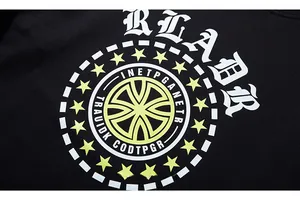 Détail du lettrage gothique RLABR et badge jaune imprimé sur un sweat-shirt noir ample