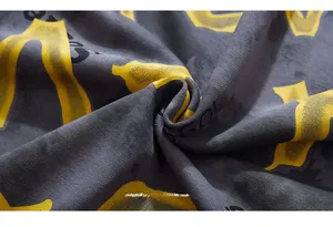 Close-up of deep gray knit fabric featuring premium yellow and black graphic prints