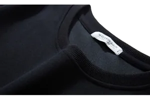 Close-up of black crew neck sweatshirt collar featuring rib-knit details and 4XL size tag