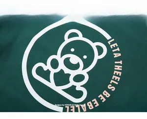 Détail de l'imprimé ours blanc avec cœur et texte sur le tissu du sweat vert foncé XL