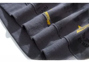 Macro shot of grey ribbed knit cuff featuring yellow and black streetwear letter prints
