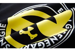 Detailed macro view of the 3D yellow embossed graphic print on black cotton fabric