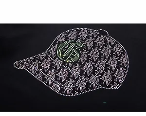 Detail of a sparkling rhinestone baseball cap design on a black cotton hoodie fabric
