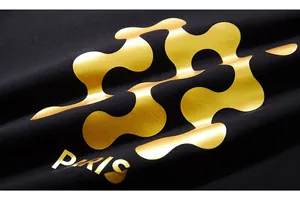 Macro detail of gold foil geometric pattern and Paris lettering on black sweatshirt