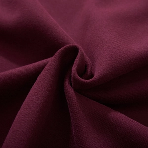 Macro shot of wine red knit hoodie fabric showing soft cotton texture and weave details