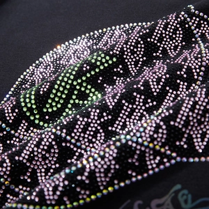 Close-up of colorful rhinestone alphabet pattern on oversized black cotton hoodie