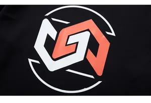 Macro d'un logo géométrique orange et blanc imprimé sur un sweat-shirt en coton noir durable