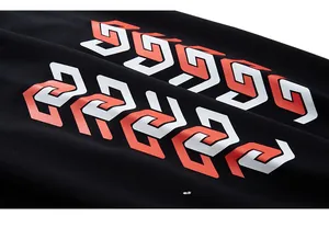 Gros plan du tissu en maille noire avec impression géométrique rouge et blanche vive