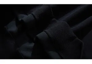 Macro detail of high-density ribbed cuff and thick knit texture on a black oversized hoodie