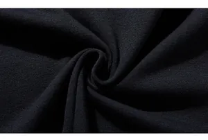 Macro shot of black knitted fabric texture showing premium cotton weave and soft drape