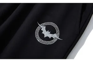 Macro shot of a bat design with glitter and rhinestones on black men's sports trousers