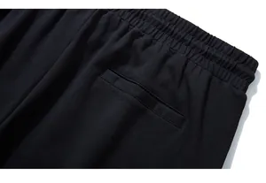 Detail of wide elastic waistband and neat welt pocket on black men's sports trousers