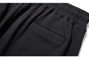 Macro detail of elastic waistband and back pocket on black embroidered joggers