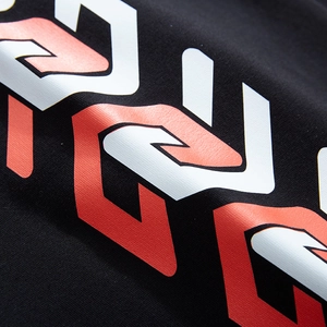 Close-up of black oversized joggers featuring vibrant red and white geometric interlocking prints