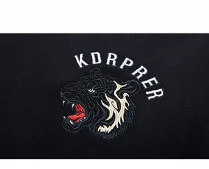 Gros plan détaillé de la broderie tête de tigre et du lettrage KDRPRER sur sweat noir