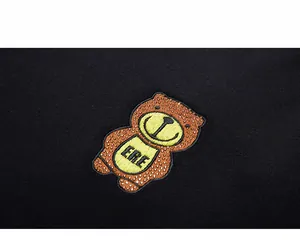 Detailed close-up of bear embroidery and sparkling rhinestones on black cotton sweatshirt