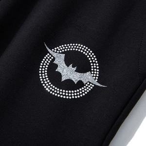 Men's black joggers featuring a silver bat logo with rhinestone circle detail