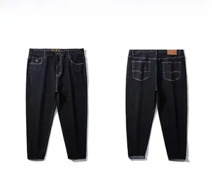 Detail of loose fit denim pants with ethnic embroidery on rolled-up cuffs and black grey wash